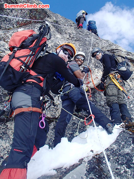 Mark , Saz and Tim climbing the rocks above basecamp. Thile Nuru Sherpa stands above. Maggie Noodle photo.