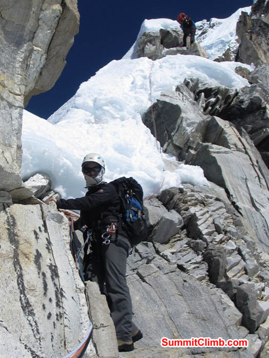 Maggie traverses granite in the white tower, while Mark climbs snow above. Photo Sarabjit Bhooee.