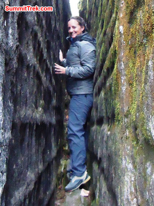 Carla squeezes between the rock walls at Kote, bringing good luck for her expedition. Photo by Andrew Davis