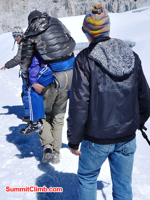 An ill porter is being carried across the mera la by his mates. photo by Michael Moritz.