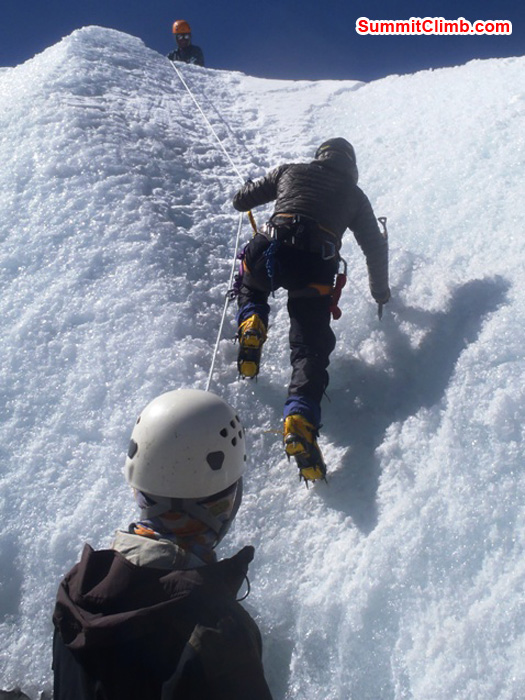 Holly Budge dashes up the ice while Jonas Lohaus watches and Lakpa Garmu Sherpa belays. Photo by Andrew Davis.