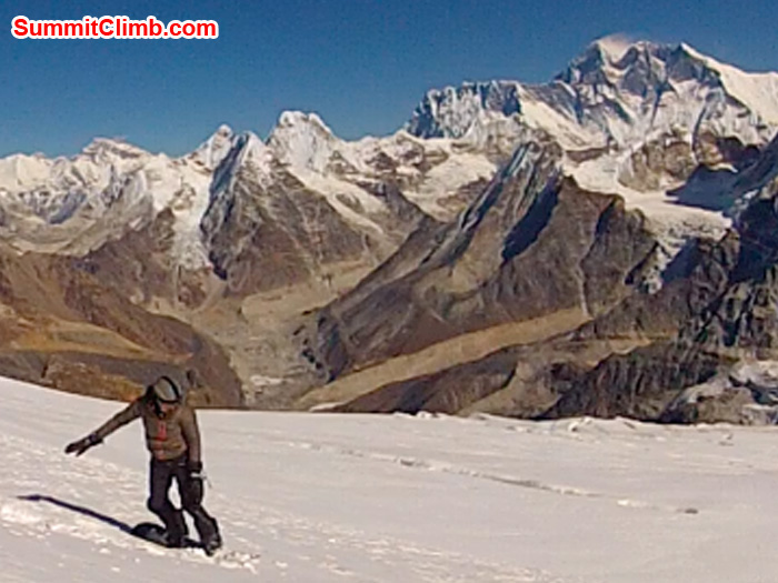 Holly Budge snowboarding down Mera Peak, with Mount Everest in the background. Photo by Corne Deelen