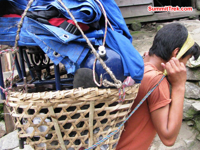 porter carrying a load of kitchen equipment. Photo by Ron and Dee Haberern
