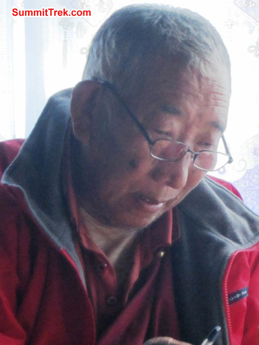 Lama Geshe the high priest of Pangboche and the upper Khumbu Valley, reads a book. Photo by Mark van 't Hof