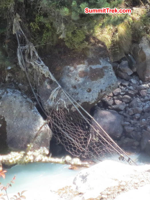 Reclining yak and a woman trekking up hill, along the trail to Everest base camp. Hannah Rolfson Photo