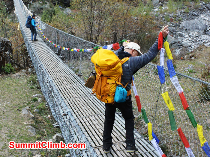 Edward and Laxman Hanging Prayer Flags on the Thada Koshi Bridge. Photo by Mike Fairman