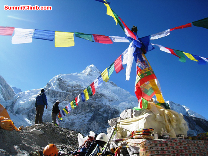 Sherpas putting up prayer flags in basecamp. Summits of Lhotse and Nuptse in background. Scott Smith Photo. Sherpas putting up prayer flags in basecamp. Summits of Lhotse and Nuptse in background. Scott Smith Photo.