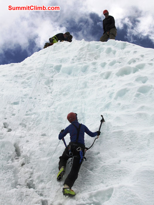 Sandra Grosskinsky climbs ice while Sange Sherpa and Anne-Mari look on. Monika Witkowska Photo. Sandra Grosskinsky climbs ice while Sange Sherpa and Anne-Mari look on. Monika Witkowska Photo.