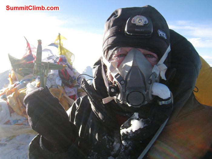 Kieran Lally on the summit, holding Bridget's Cross made of reed. Photo by Scott Smith.