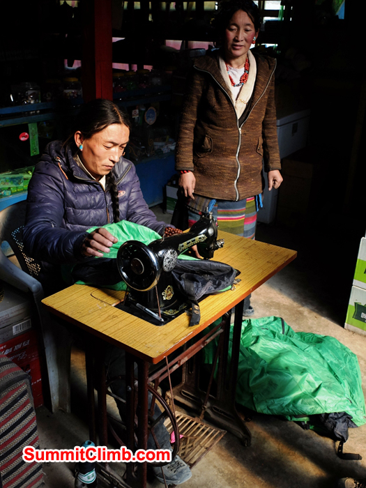 Chimi and Dolma repairing a basecamp tent in SummitClimb Cho Oyu and Shishapangma storeroom