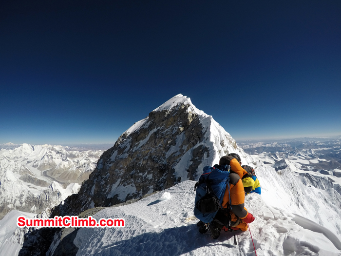Climber helping mate after summit of Everest