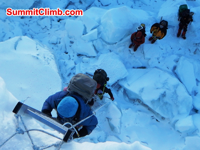 Paula cimbs a five section ladder in the Khumbu icefall while Lhakpa, Cat, James, and Karma wait patiently. Mike Fairman Photo