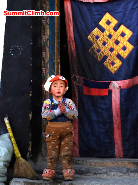 Tingri boy in doorway with broom